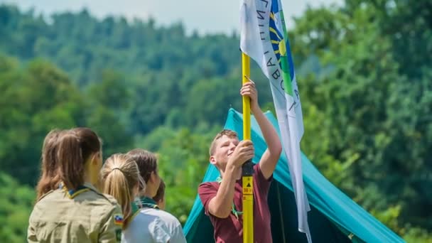 Domzale Slovenia 2018年07月若いスカウトが旗を掲げている 残りの斥候は彼を見ている — ストック動画
