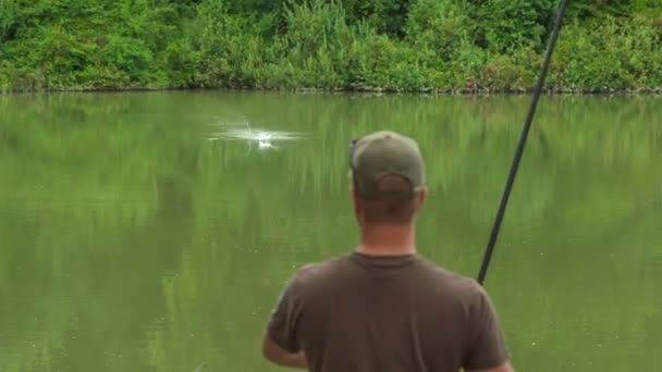 Ένας Ψαράς Τυλίγει Γρήγορα Ένα Καλάμι Ψαρέματος Επειδή Έπιασε Ένα — Αρχείο Βίντεο
