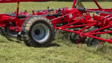 Bir çiftçi büyük bir tarlada saman hazırlarken döner tırmıklar çok hızlı hareket eder. Yapacak çok işi var..