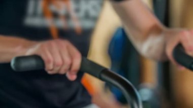 DOMZALE, SLOVENIA - 17. JULY 2018 Genç bir adam spor salonunda çalışıyor ve diğer egzersizler arasında bazı kardiyo egzersizleri yapıyor..