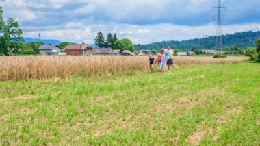 Genç bir aile tarlalara doğru koşuyor ve harika vakit geçiriyorlar. Doğa çok güzel ve hava mükemmel..