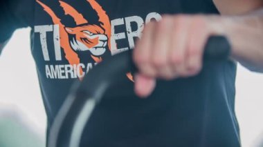 DOMZALE, SLOVENIA - 17. Temmuz 2018 'de genç bir adam spor salonunda antrenman yapıyor. Kollarını hareket ettirdiği bir cihaz üzerinde çalışıyor..