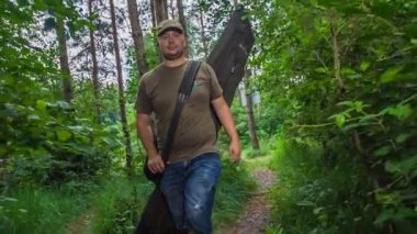 Bir balıkçı göle ulaşmak için ormanda yürüyor..