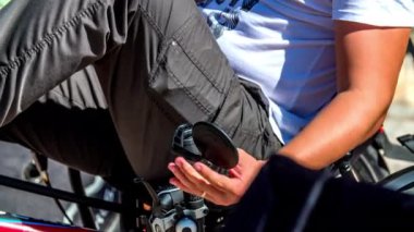 Bir adam bisikletin yan aynasını ayarlıyor..