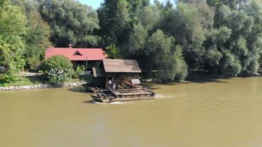 Güneşli bir günde nehirdeki eski su değirmeninin hava görüntüleri.