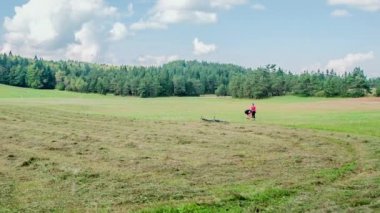 Bir çift büyük yeşil bir çayırın ortasında dinleniyor. Bisikletlerini yeni kesilmiş gras 'nın yanına bırakıyorlar..