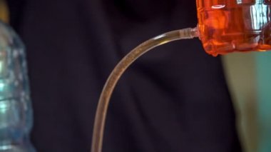Öğrenciler kimya dersi alıyorlar ve plastik şişeler ve kırmızı sıvı ile bir deney yapıyorlar..