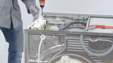 Servis merkezindeki çamaşır makinesinin yakın çekim görüntüleri.