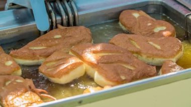 DOMZALE, SLOVENIA - 15. HAZİRAN 2018 Kızarmış donut yapan biri hazır olup olmadığını kontrol ediyor..