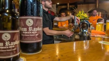 DOMZALE, SLOVENIA - 16. HAZİRAN 2018 Bir bar hayat dolu bu gece. Arman bira dolduruyor, insanlar içiyor ve iyi vakit geçiriyor..