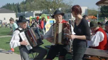 DOMZALE, SLOVENIA - 17. Haziran 2018 Klarnetli bir bayan ve akordeonlu iki adam. Bu etkinlikte ziyaretçiler için çalıyorlar..