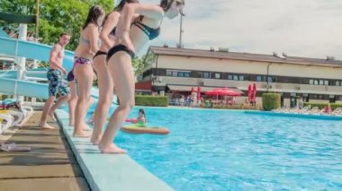 DOMZALE, SLOVENIA - 20. Haziran 2015 'te gençler birbiri ardına yüzme havuzuna atlıyorlar. Havuz başında eğleniyorlar..