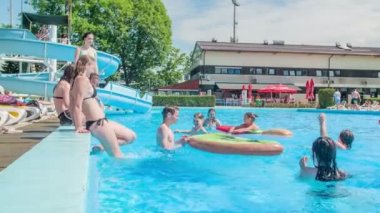 DOMZALE, SLOVENIA - 20. Haziran 2015 gençleri birbirlerine su sıçratıyorlar. Havuz kenarında sıcak bir yaz günü..