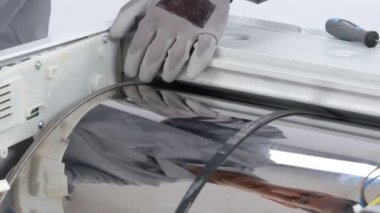 Servis merkezindeki çamaşır makinesinin yakın çekim görüntüleri.