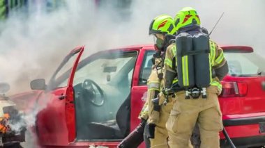 DOMZALE, SLOVENIA - 7. Temmuz 2018 İtfaiyeciler itfaiye operasyonu yapıyorlar. Yanan bir araçtan bir kişiyi kurtarıyorlar. Hızlı olmaları gerek. Çok zahmetli bir iş..