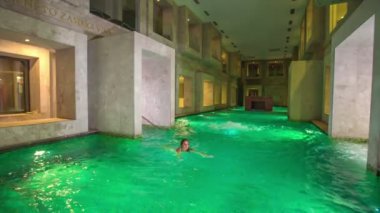 RIMSKE TOPLICE, SLOVENIA - 15. Eylül 2018 Rimske Terim adlı güzel bir tatil köyünde güzel, yeşil bir su. Roma tarzında tasarlanmıştır. Havuzda sadece bir bayan yüzüyor..