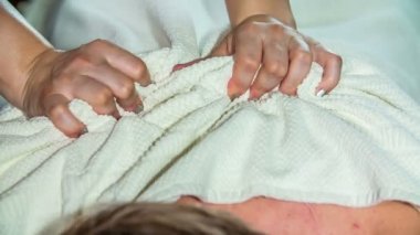 Bir masör müşterisinin kaslarını gevşetiyor. Yağ masajı yapacak..