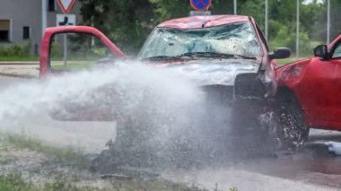 DOMZALE, SLOVENIA - 7. HAZİRAN 2018 Bir su jeti yanan bir aracı söndürüyor. İtfaiyeciler itfaiye operasyonu yapıyor..