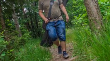 Bir balıkçı göle ulaşmak için dar bir orman yolunda yürüyor. Balığa gidiyor..