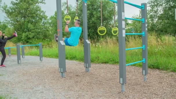 Man Slowly Lifting Himself Rings Practising Outdoors Doing Strength Exercises — Stock Video