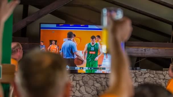 Domzale Slovenia 7月2018このバーのファンの一人はバスケットボールの試合を見ているときに空気中で彼のガラスを持ち上げています — ストック動画