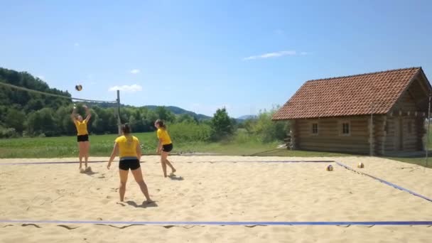 Dört Kız Voleybol Oynuyor Kumlu Bir Voleybol Sahasında — Stok video