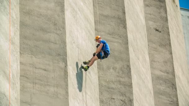 Bir Dağcı Binanın Tepesine Ulaşmak Için Ipe Tırmanırken Aşağı Bakar — Stok video