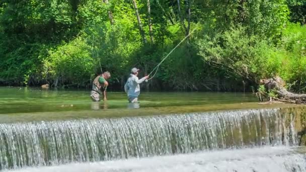 暑い夏の日に二人の男が釣りをしている 川は美しく見える — ストック動画