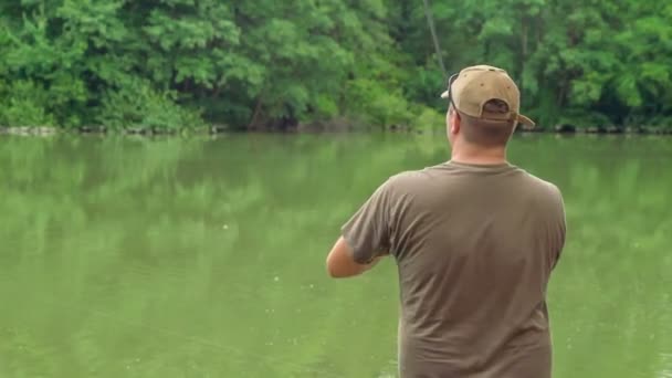 Fiskare Slingrar Ett Fiskespö För Att Han Fångade Fisk — Stockvideo