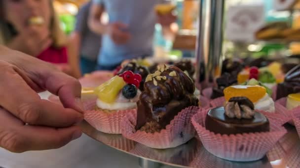 Domzale Slovenia 6月2018お母さんはおいしいカップケーキの1つの部分をつかみ 味わう この市場では家族全員が異なるものをサンプリングしています — ストック動画