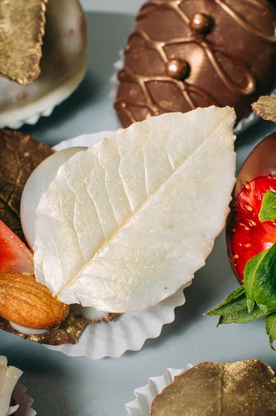 Witte chocolade blad versierd met eetbare gouden glans — Stockfoto