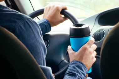 Males hand holding thermo mug