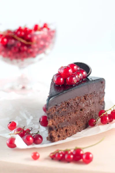 Torta de chocolate com corrente vermelha no fundo branco — Fotografia de Stock