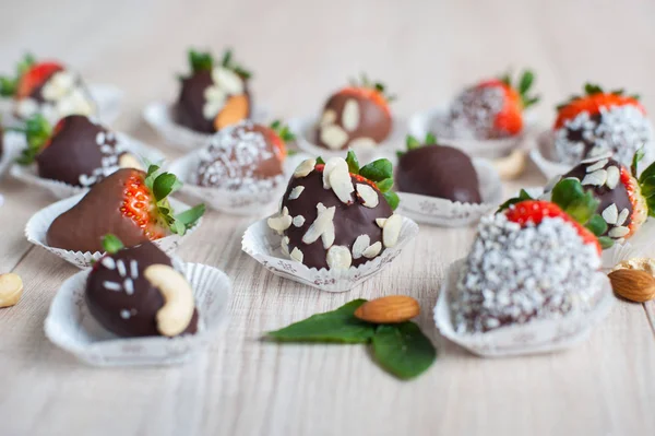 Strawberry covered with chocolate and almond nuts — Stockfoto