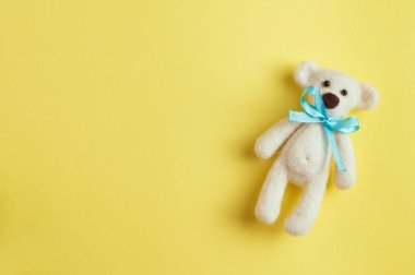 Sarı arka planda turkuaz düğümlü ayı oyuncağı
