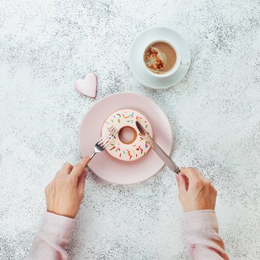 Gri taşlı sırt grubunda donut biçimli bisküvi kesen kadın elleri