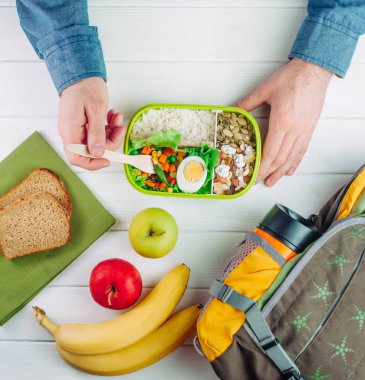 Erkek ellerinin beslenme çantasından ahşap bir sırt deliğinde yemek yediği en iyi manzara.