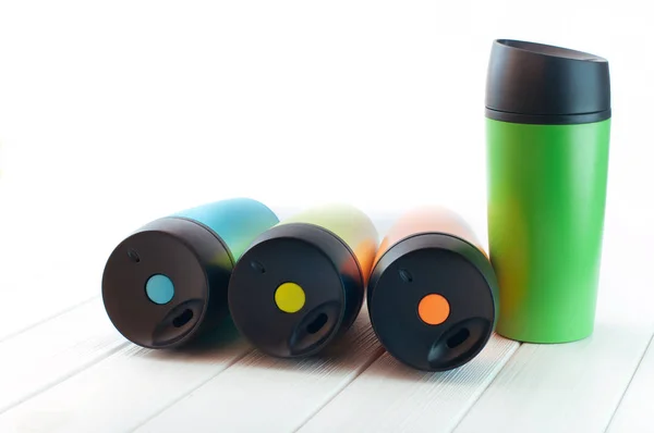 Tasses thermos couleur sur le fond blanc en bois avec copie spac — Photo