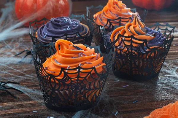 Halloween cupcakes på rustika träbord täckt med webben — Stockfoto