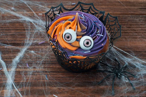 Halloween cupcake på rustika träbord täckt med webben — Stockfoto