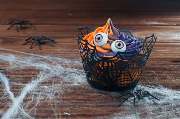Halloween cupcake med ögon på rustika träbord täckt med — Stockfoto