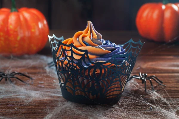 Halloween cupcake på rustika träbord täckt med webben och sp — Stockfoto