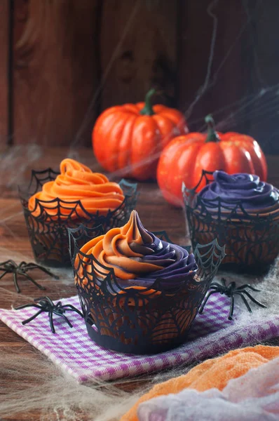 Halloween cupcakes på rustika träbord täckt med webben — Stockfoto