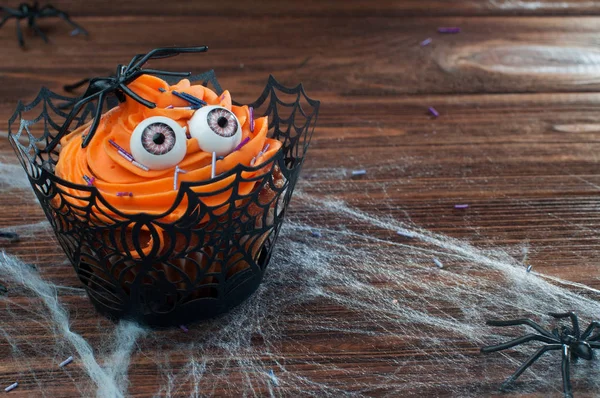 Halloween cupcake på rustika träbord täckt med webben — Stockfoto