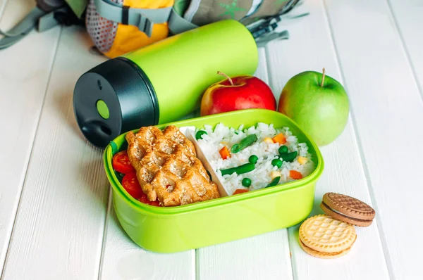 Lunch box near thermos, fresh apples and biscuits in front of sc — Stock Photo, Image