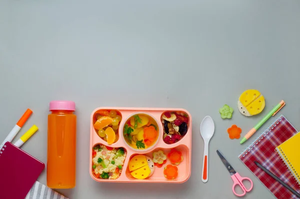 Caja de almuerzo con zumo de naranja y notebooks en fondo gris. — Foto de Stock