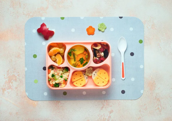 Lunch box with vegetable soup, couscous salad and funny sandwich