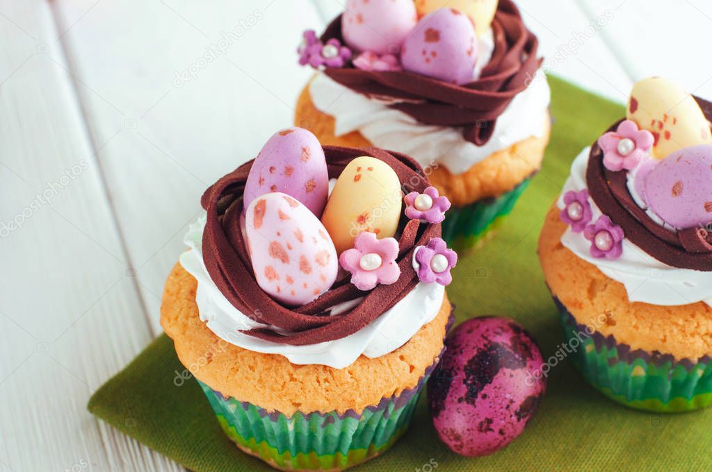 Closeup of Easter nest shape cupcakes on light wooden background