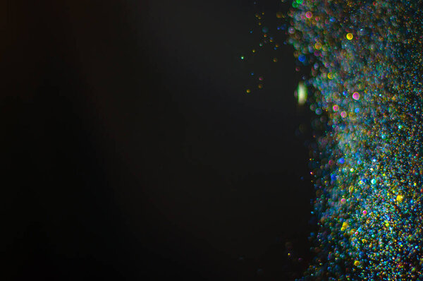 Abstract background with glittering defocused bokeh multicolor particles