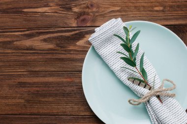 Kırsal ahşap arka planda keten peçete, filiz ve tarçınlı bayram sofrası ve metin için boş alan. Üst manzara, düz uzanma.